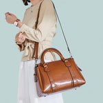Brown leather purse with crossbody strap and top handles