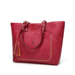 Red leather tote bag with tassels